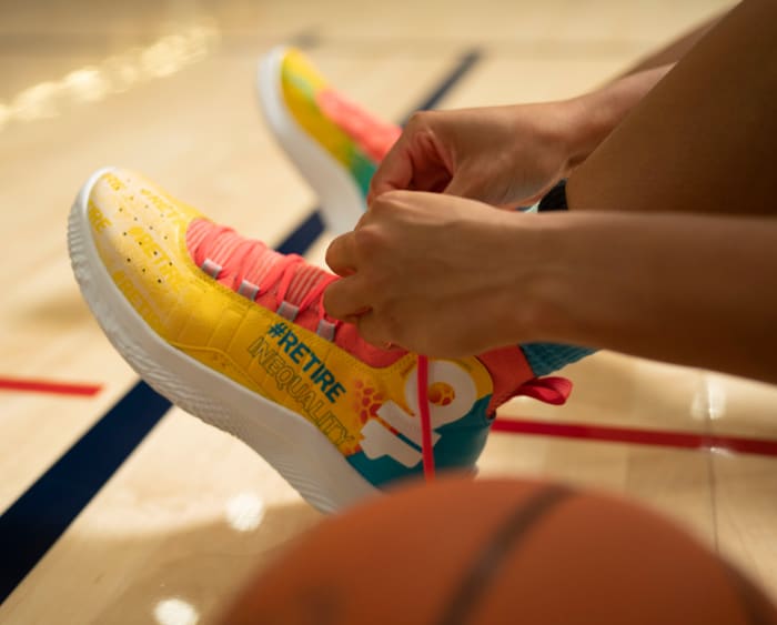 Azzi Fudd laces up a pair of #RetireInequality shoes.